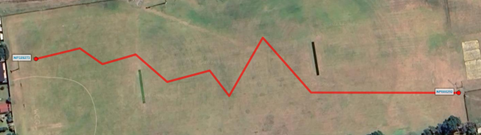 Highlighted pipe with multiple bends shown on a utility map before using the Simplify Pipe tool. The pipe connects two pits and is displayed in a prominent color, while surrounding pits and pipes are muted. The map interface is functional and neutral, focusing on utility mapping. No visible text in the image.